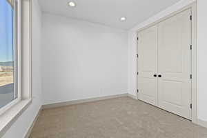 Unfurnished bedroom with a closet and light carpet