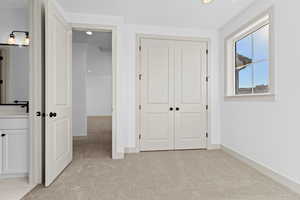 Unfurnished bedroom with a closet and light carpet