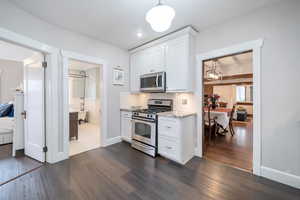 Kitchen featuring white cabinetry, decorative backsplash, dark hardwood / wood-style floors, and appliances with stainless steel finishes