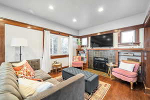 Living room with dark hardwood / wood-style flooring and a fireplace