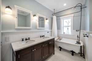 Bathroom featuring ornamental molding, tile patterned floors, vanity, and a bathtub