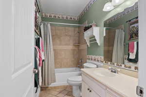 Full bathroom with vanity, toilet, and shower / bath combo with shower curtain