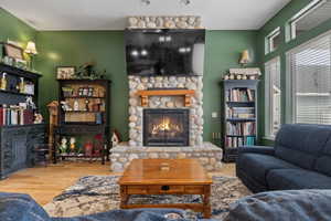 Living room with a fireplace and wood-type flooring