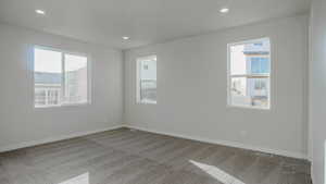 Carpeted spare room featuring a wealth of natural light, baseboards, and recessed lighting