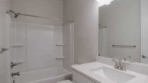 Bathroom with toilet, vanity, and  shower combination