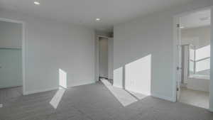 Unfurnished bedroom featuring carpet flooring, recessed lighting, ensuite bath, and baseboards