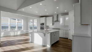 Kitchen with dark wood-style floors, built in microwave, oven, wall chimney exhaust hood, and backsplash