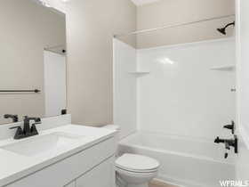 Full bathroom featuring shower / bath combination, vanity, and toilet