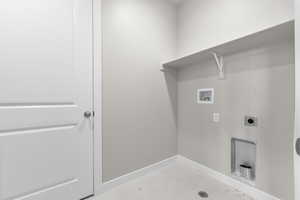 Washroom with electric dryer hookup, light tile patterned floors, and hookup for a washing machine