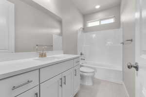 Full bathroom with vanity, toilet, tile patterned flooring, and shower / bathing tub combination