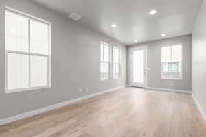 Empty room featuring a textured ceiling and light wood-type flooring