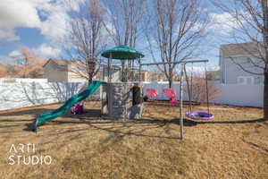 View of jungle gym with a lawn