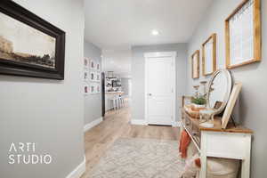 Corridor with light hardwood / wood-style flooring