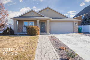 Ranch-style home with a garage, covered porch, and a front yard