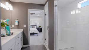 Bathroom with an enclosed shower, vanity, and tile patterned flooring