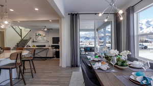 Dining area with a tiled fireplace, hardwood / wood-style floors, and ceiling fan