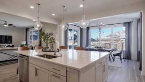 Kitchen with white cabinetry, sink, a kitchen island with sink, and a mountain view