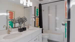 Full bathroom with vanity, tile patterned flooring, toilet, and tiled shower / bath