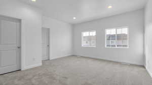 Empty room featuring light colored carpet