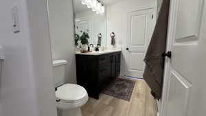 Bathroom with wood finished floors, vanity, and toilet