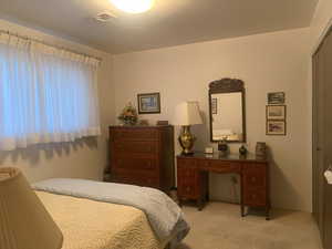 Bedroom featuring light carpet and a closet