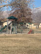 View of play area with a mountain view and a yard