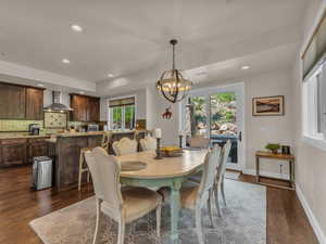 Dining area featuring dark wood-style flooring, a chandelier, recessed lighting, and baseboards