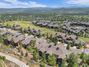 Aerial view of property's location with mountains, nearby suburban area, and a golf course