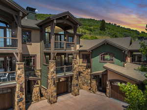Property at dusk with an attached garage, driveway, and central AC unit