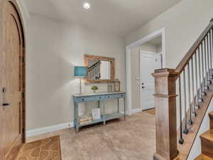 Foyer entrance with stairs and baseboards