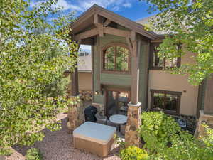 Back of house featuring stone siding and a patio