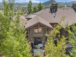 View of front of home featuring roof with shingles, stone siding, and a mountain view