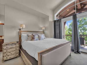Carpeted bedroom featuring access to exterior and vaulted ceiling