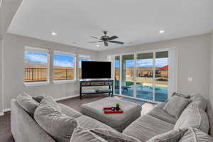 Living room with dark hardwood / wood-style floors and ceiling fan