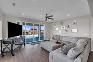 Living room with dark hardwood / wood-style floors and ceiling fan