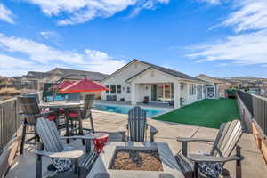 View of pool featuring an outbuilding, a yard, a fire pit, and a patio area