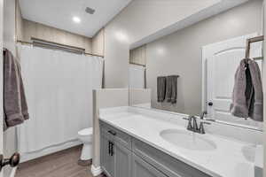 Bathroom featuring hardwood / wood-style flooring, vanity, and toilet