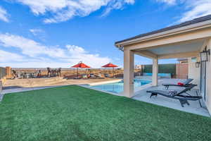 View of yard featuring a fenced in pool and a patio