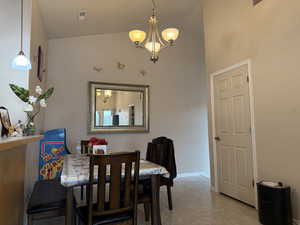 Dining area with lofted ceiling and a notable chandelier