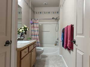 Full bathroom with vanity, shower / bath combo, tile patterned floors, and toilet