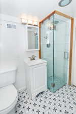 Bathroom featuring vanity, toilet, and walk in shower