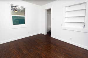 Unfurnished bedroom with dark hardwood / wood-style flooring