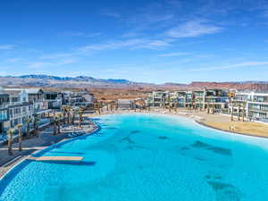 View of swimming pool with a water and mountain view and a view of the beach