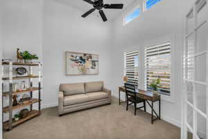 Carpeted living room with ceiling fan