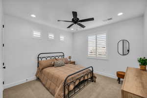 Carpeted bedroom featuring ceiling fan