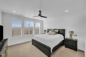 Carpeted bedroom featuring ceiling fan