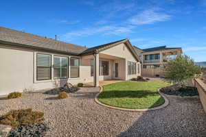 Rear view of property featuring a patio and a lawn