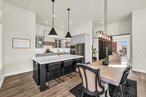 Dining area featuring sink, hardwood / wood-style flooring, and a high ceiling