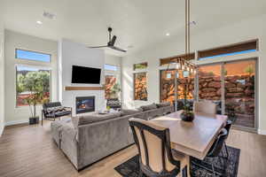 Dining room with ceiling fan, a large fireplace, and light wood-type flooring