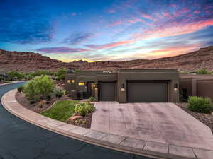 Pueblo-style house featuring a garage and a mountain view